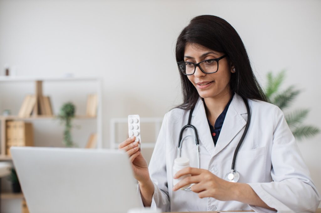 Hindu doctor consulting patient on video call in office
